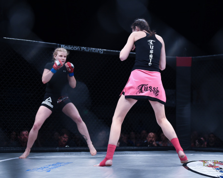 Female MMA fighters facing each other.